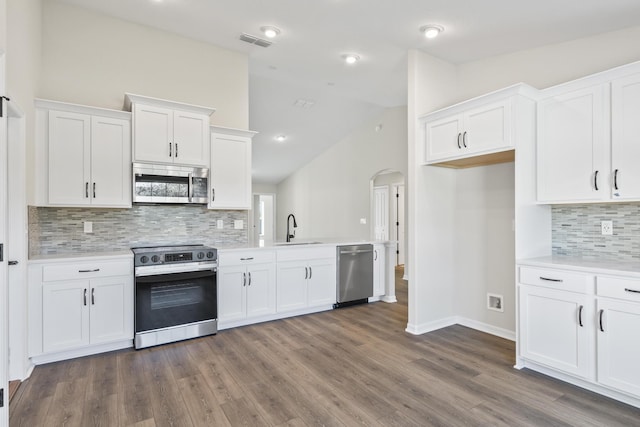 kitchen featuring visible vents, light countertops, appliances with stainless steel finishes, arched walkways, and a sink