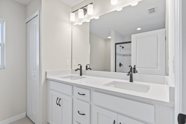 full bath with double vanity, visible vents, a stall shower, and a sink