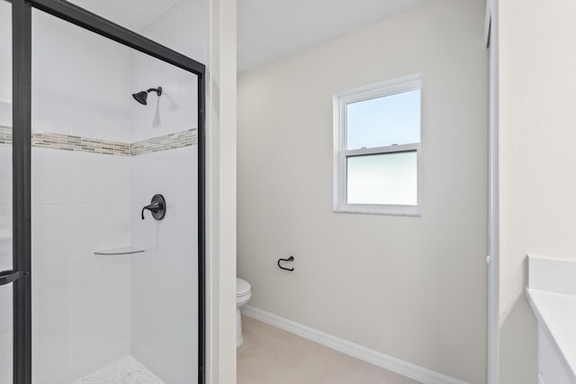 bathroom featuring a shower stall, toilet, and baseboards