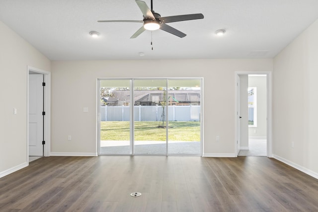 unfurnished room with baseboards, wood finished floors, and ceiling fan