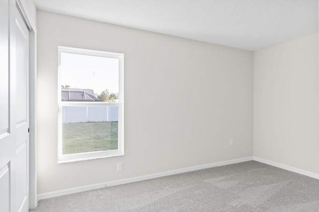 carpeted spare room with baseboards