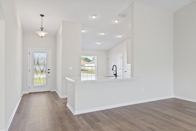 entrance foyer with vaulted ceiling, wood finished floors, visible vents, and baseboards