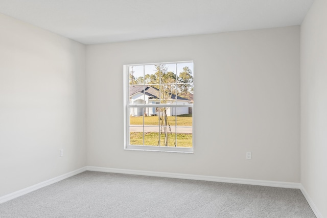 carpeted spare room with baseboards