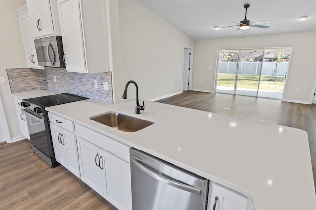 kitchen with ceiling fan, a sink, light countertops, appliances with stainless steel finishes, and open floor plan