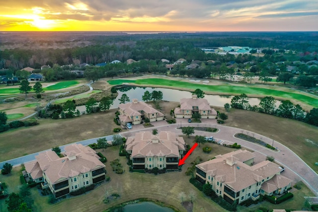 aerial view at dusk featuring a water view and a residential view