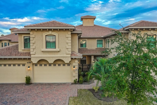 mediterranean / spanish house featuring decorative driveway and stucco siding