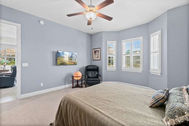 bedroom with light carpet, a ceiling fan, and baseboards