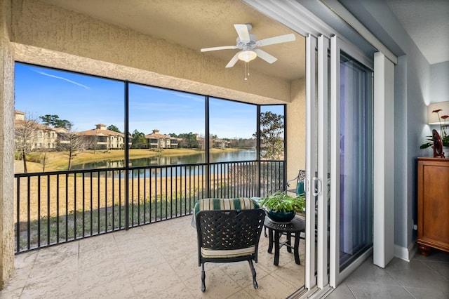 sunroom with a water view and ceiling fan