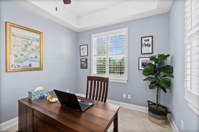 office space with a ceiling fan and baseboards