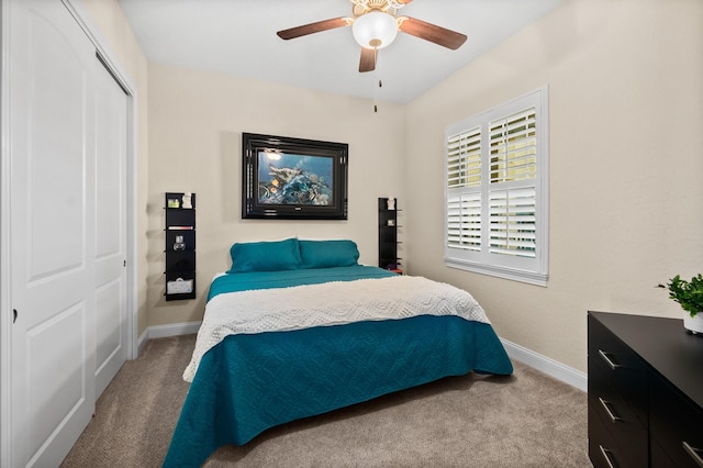 bedroom with light carpet, baseboards, and a closet