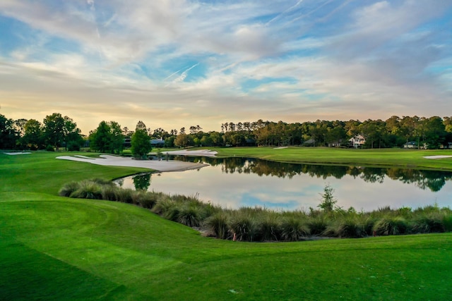 surrounding community with golf course view, a water view, and a lawn