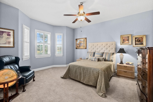 bedroom featuring light colored carpet, ceiling fan, and baseboards