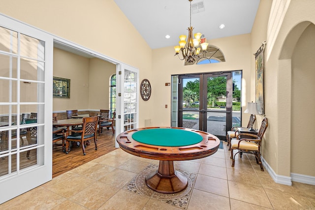 recreation room featuring light tile patterned floors, high vaulted ceiling, a notable chandelier, visible vents, and french doors