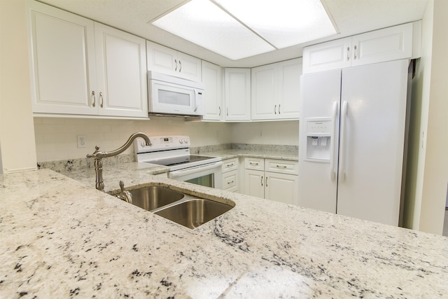 890 A1A Beach Blvd Unit 74, Saint Augustine Beach, FL 32080 - kitchen featuring white appliances, light stone countertops, white cabinets, and backsplash