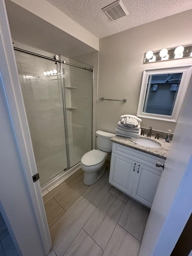 890 A1A Beach Blvd Unit 74, Saint Augustine Beach, FL 32080 - bathroom featuring a textured ceiling, a shower stall, and vanity