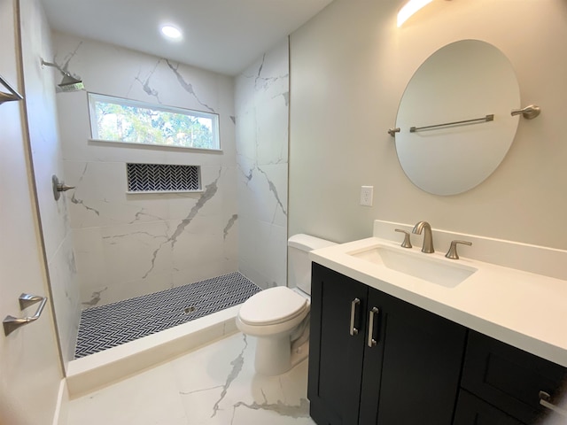 bathroom featuring tiled shower, vanity, and toilet