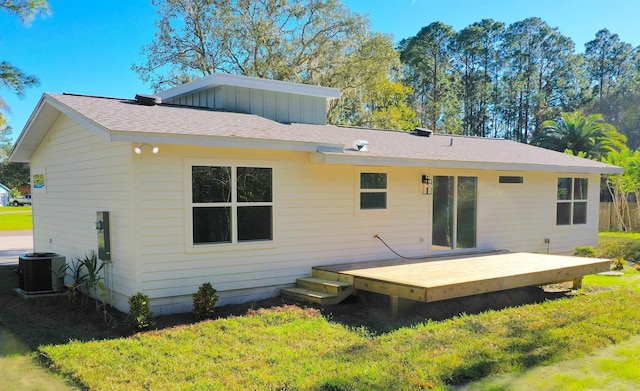 rear view of property featuring a deck, a yard, and central AC