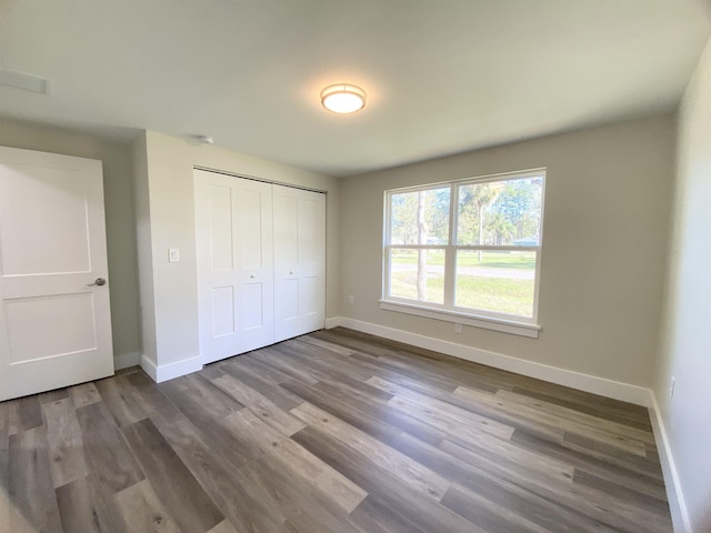 unfurnished bedroom with wood-type flooring and a closet