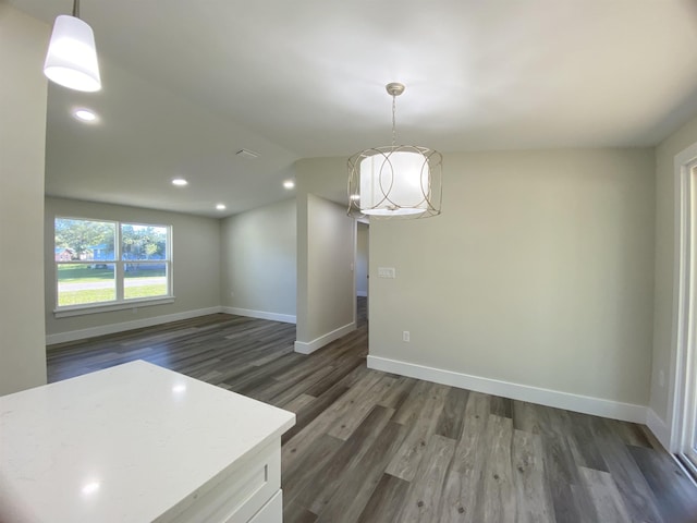 unfurnished dining area with dark wood-type flooring