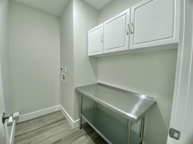 clothes washing area with washer hookup, hookup for an electric dryer, cabinets, and light wood-type flooring