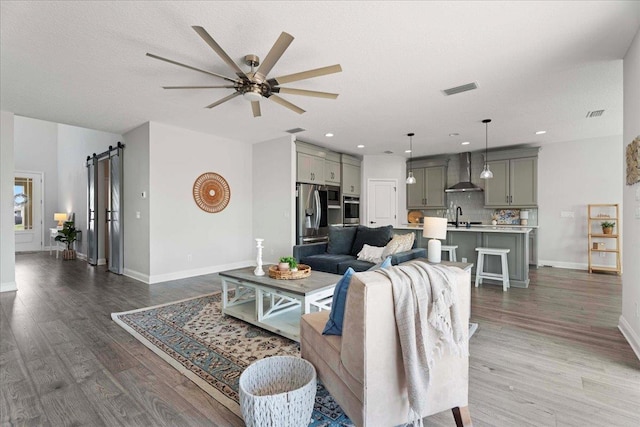 295 Ferndale Way, Saint Augustine, FL 32092 - living area featuring a barn door, ceiling fan, wood finished floors, baseboards, and recessed lighting