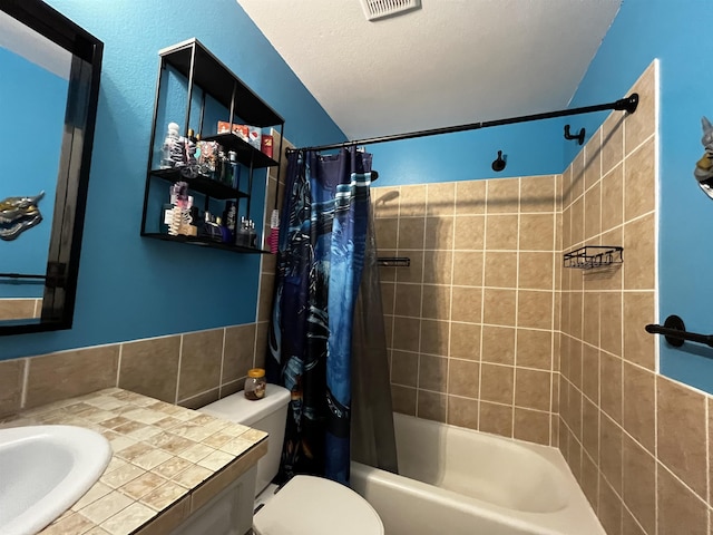 full bathroom with vanity, a textured ceiling, toilet, and shower / bathtub combination with curtain