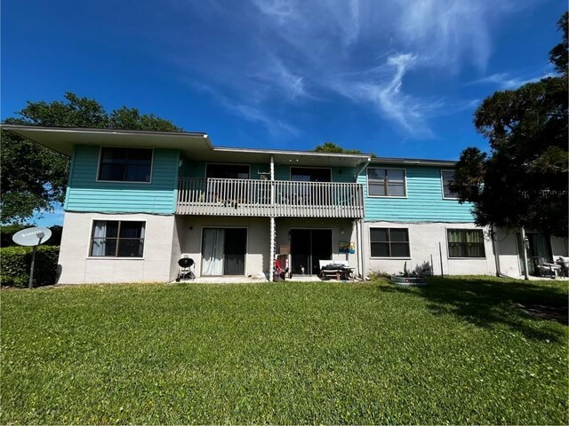 rear view of house featuring a lawn