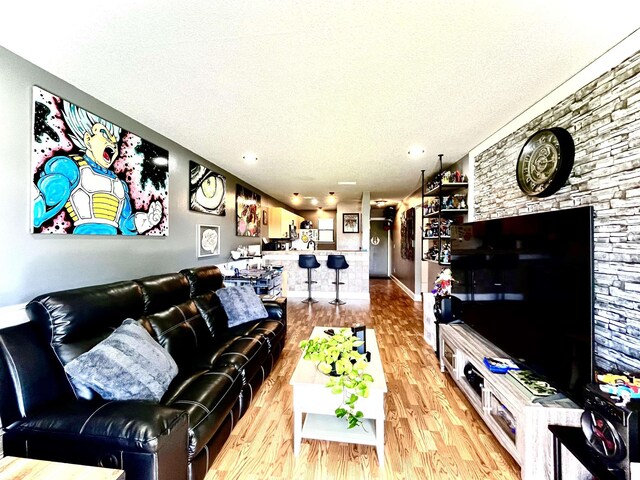 living room with light wood-type flooring and a textured ceiling