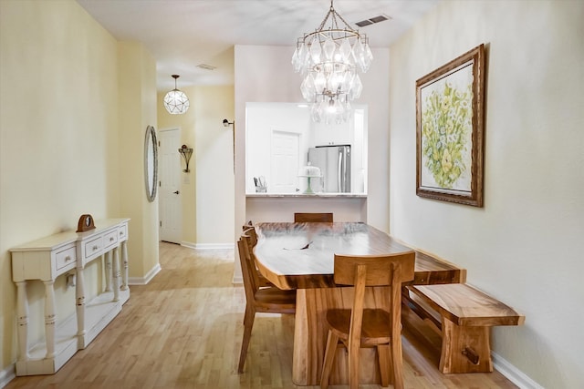 dining room with a notable chandelier and light hardwood / wood-style flooring