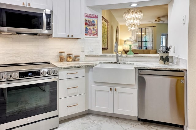 kitchen featuring white cabinets, light stone counters, and stainless steel appliances