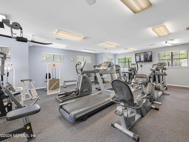 gym with ceiling fan and a healthy amount of sunlight