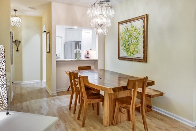 dining area featuring an inviting chandelier and light wood-type flooring