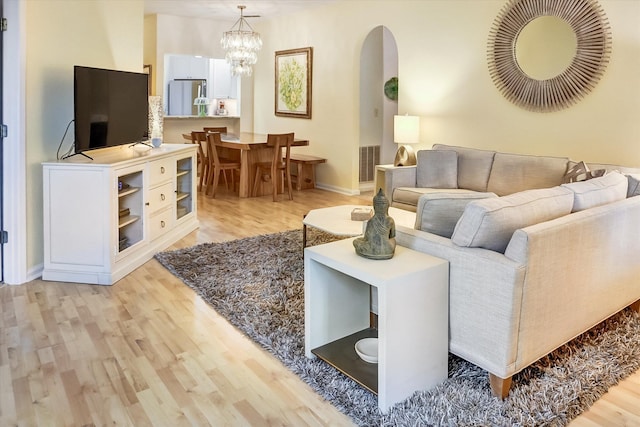 living room featuring a chandelier and light hardwood / wood-style floors