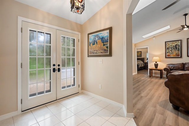 doorway with ceiling fan, light hardwood / wood-style floors, lofted ceiling, and french doors