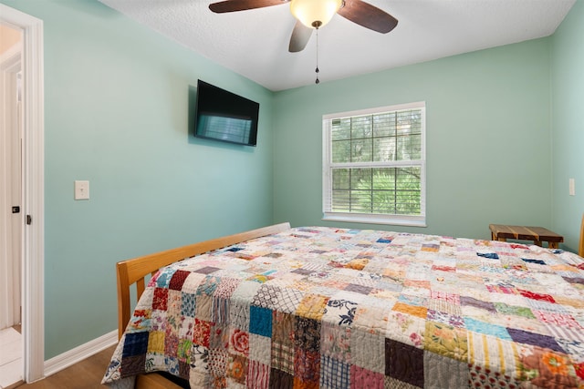 bedroom with ceiling fan and hardwood / wood-style floors