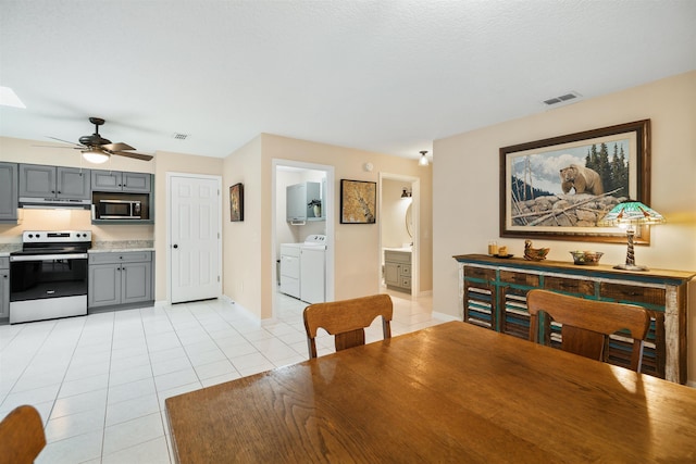 tiled dining room with ceiling fan and washer and clothes dryer