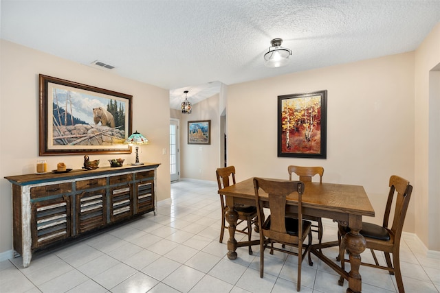 tiled dining area featuring a textured ceiling