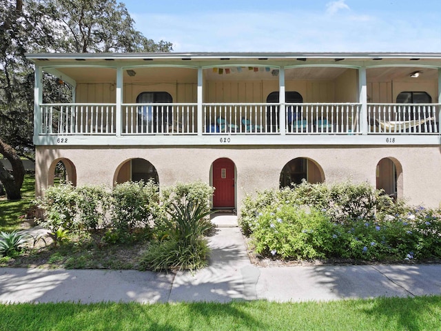 view of front facade featuring a balcony and stucco siding