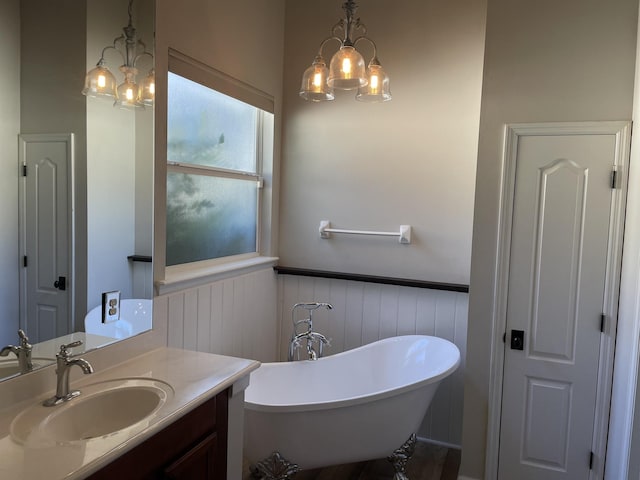 bathroom with vanity, an inviting chandelier, and a bathtub