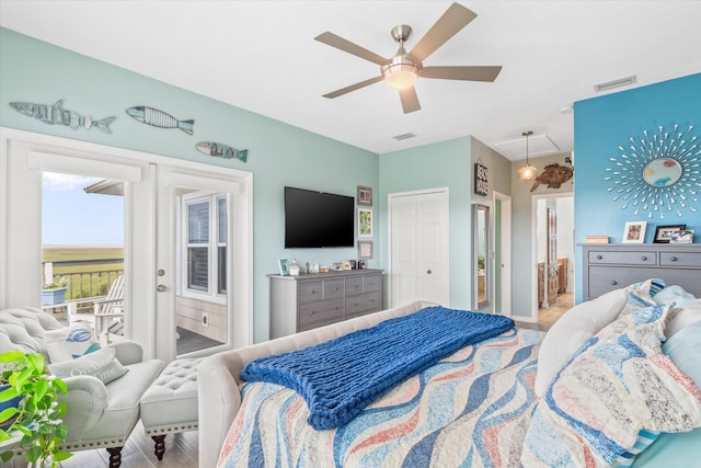 bedroom featuring ensuite bath, ceiling fan, and multiple windows