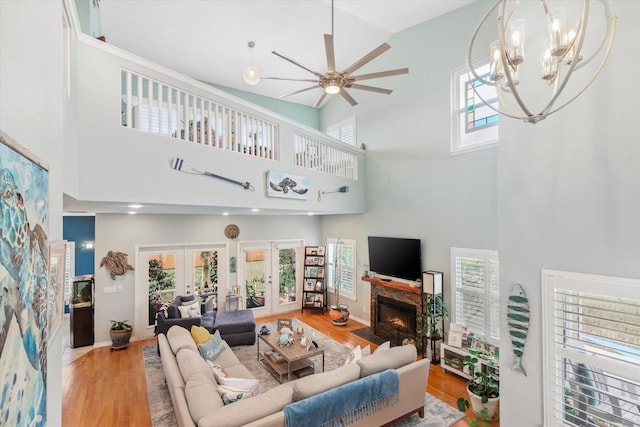 living room featuring a wealth of natural light, french doors, high vaulted ceiling, and light hardwood / wood-style flooring