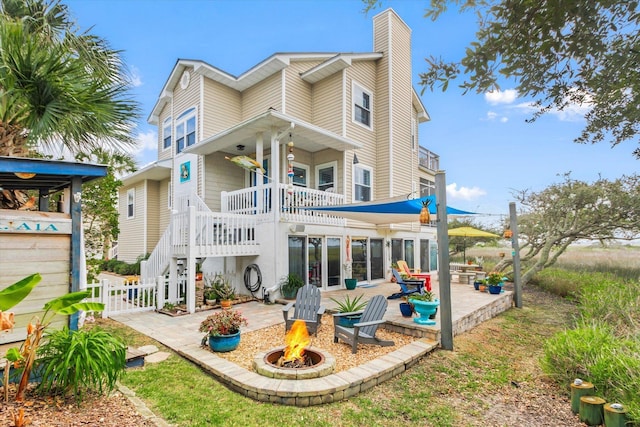 rear view of house with a patio area and a fire pit