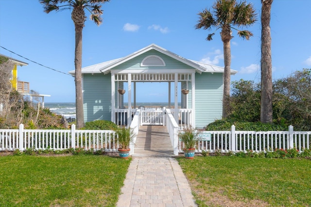 view of front facade with a water view and a front lawn