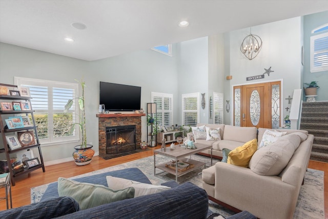 living room with a fireplace, a chandelier, light hardwood / wood-style flooring, and plenty of natural light