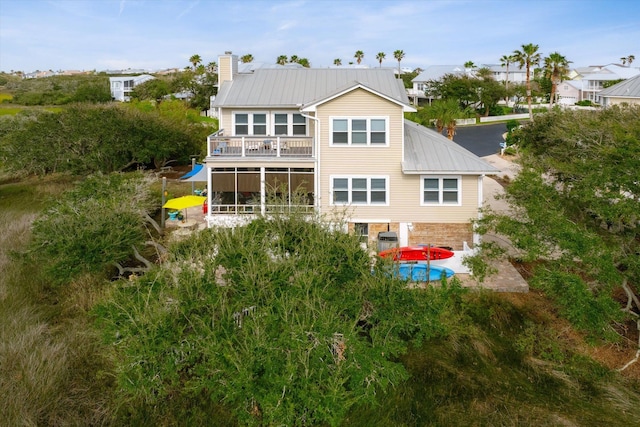 rear view of property featuring a patio and a balcony