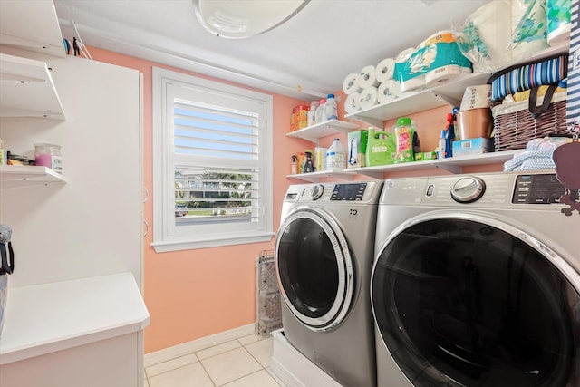 clothes washing area with light tile patterned flooring and washer and dryer