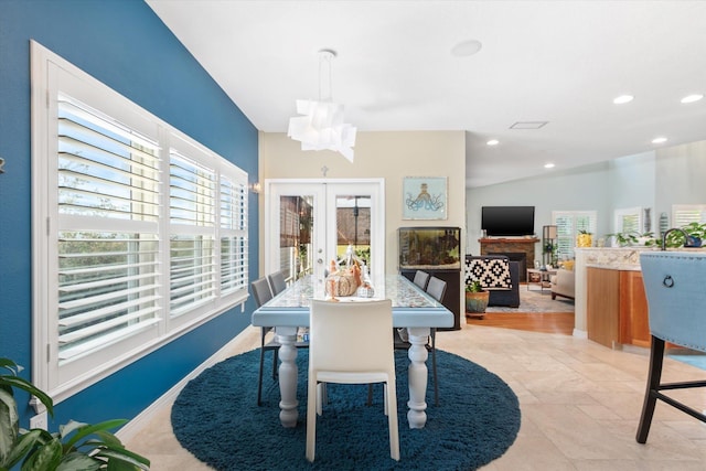 dining area with french doors, vaulted ceiling, and an inviting chandelier