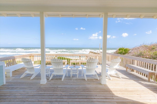 wooden deck with a water view and a view of the beach