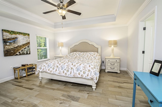 bedroom with ceiling fan, light wood-type flooring, crown molding, and a tray ceiling