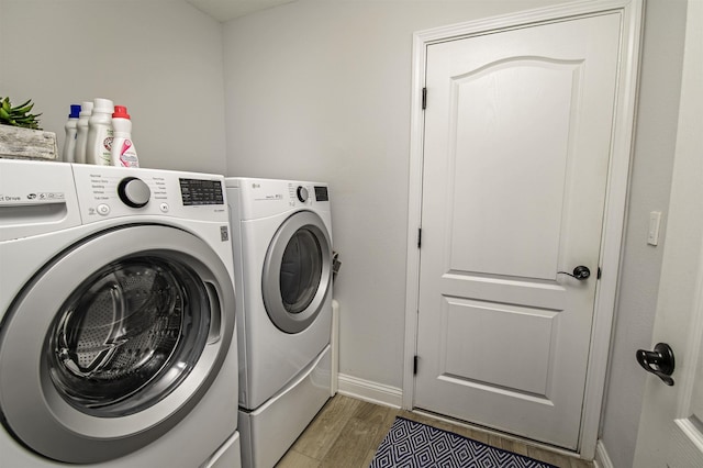 laundry area featuring washing machine and dryer and hardwood / wood-style floors